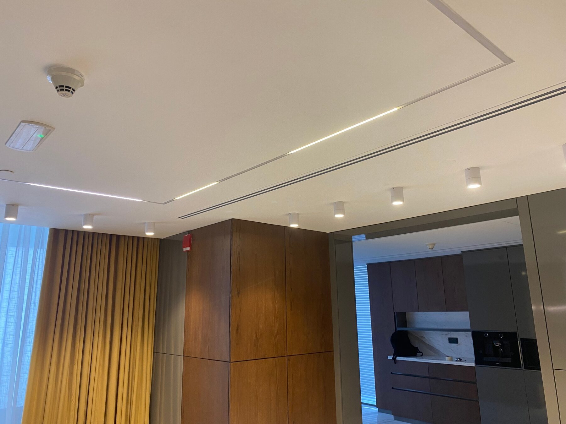 Completed seamless ceiling with integrated linear lighting and spotlights