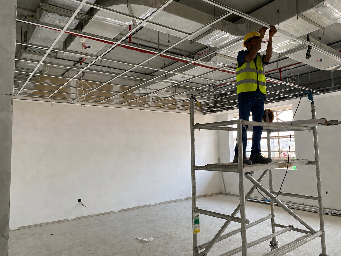 White Waves installer working safely on a commercial ceiling grid